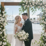 Mr. and Mrs. with wooden arch at Naples Bay Resort
