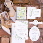 Wedding details including invitation, city map, rsvp card, bride's heels, and wedding rings